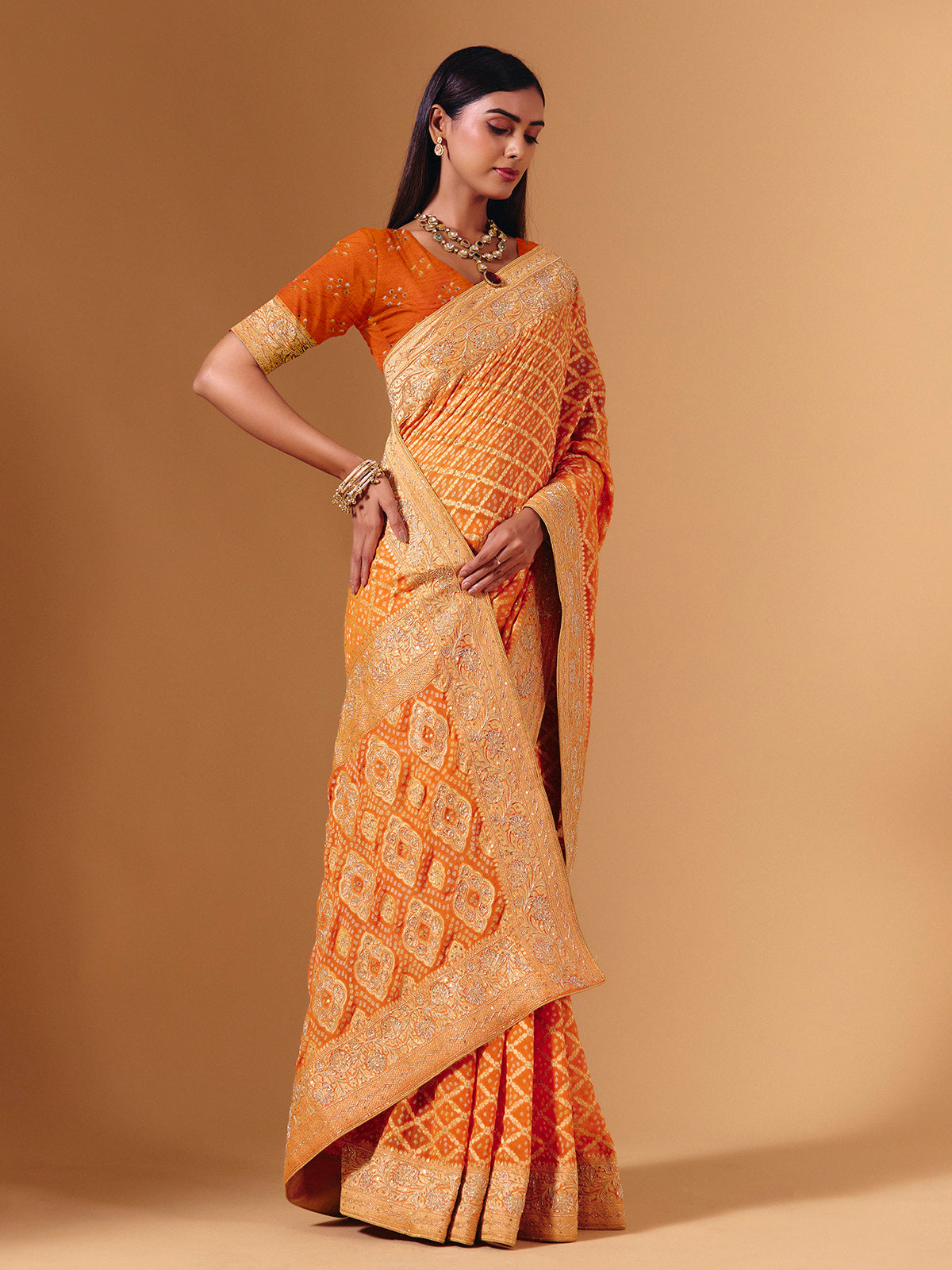 Orange georgette saree with bandhani print and zardosi embellishments