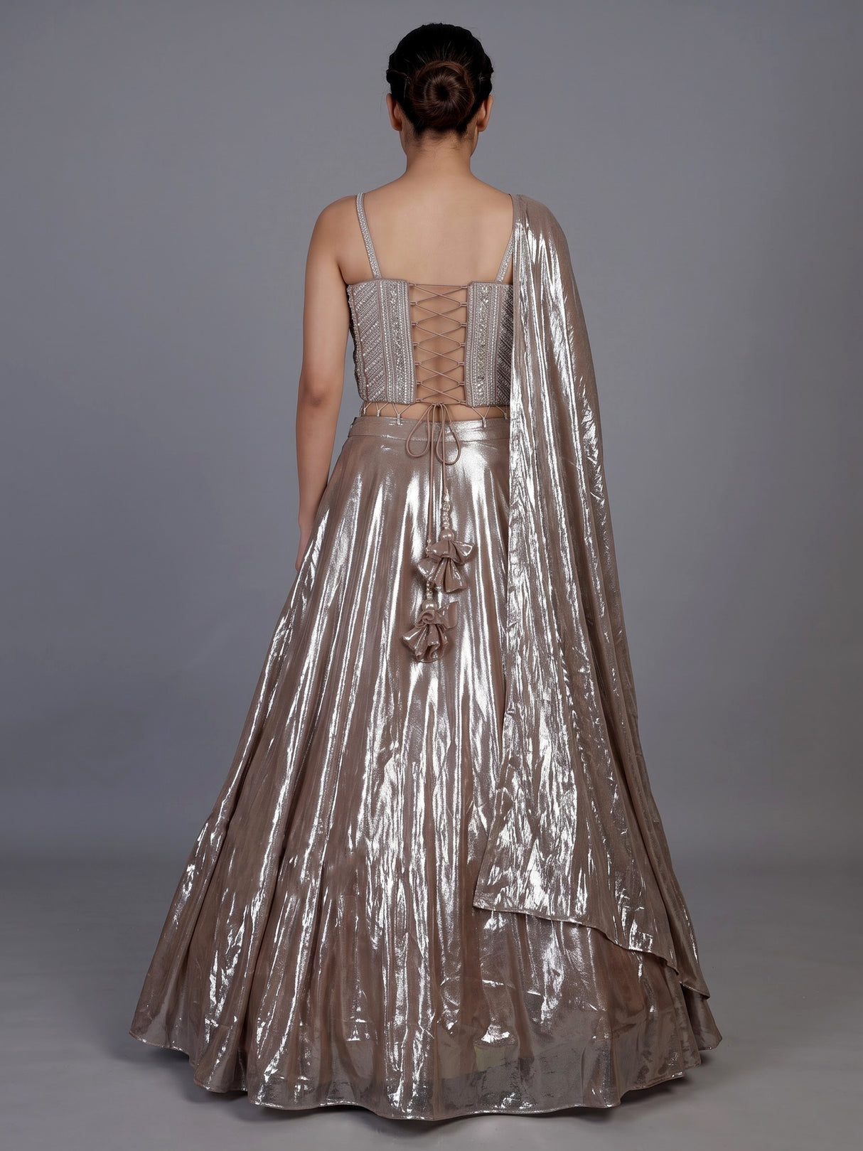 Sophisticated beige shimmer tissue silk lehenga choli with tassel accents