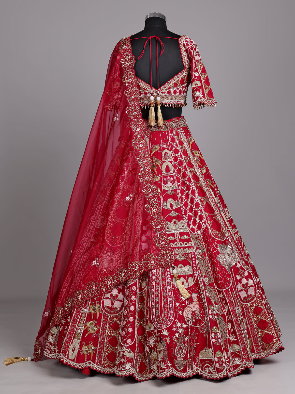 Maroon raw silk lehenga choli with artistic motifs and tassels