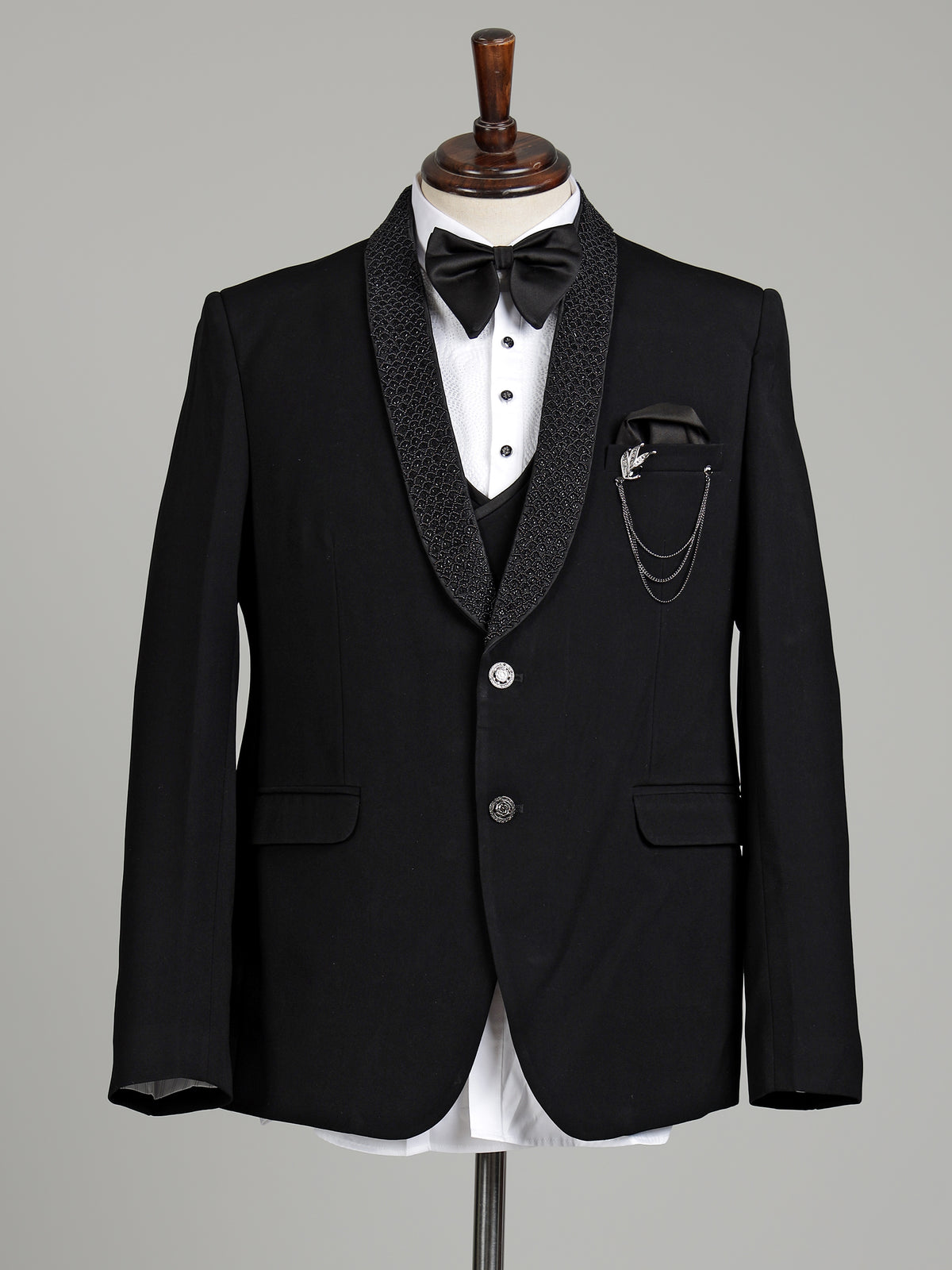Jet black three-piece tuxedo suit with crystal brooch and cutdana