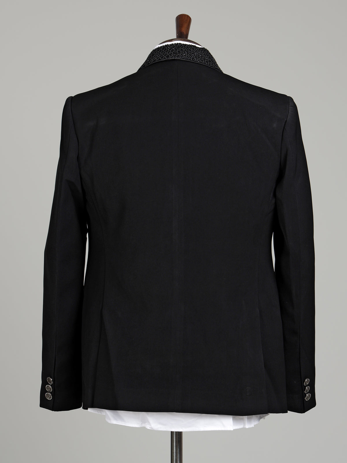 Jet black three-piece tuxedo suit with crystal brooch and cutdana