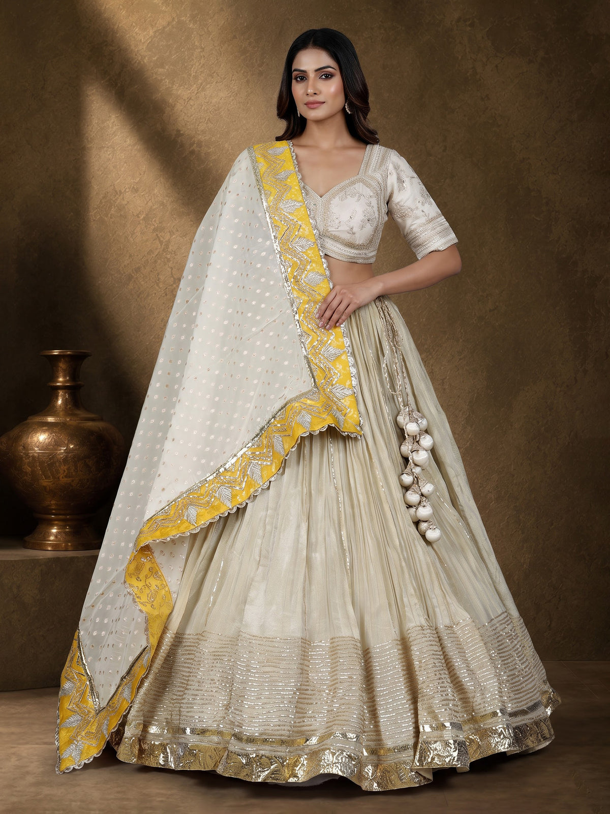 Beige silk lehenga choli with traditional aabla and gota work