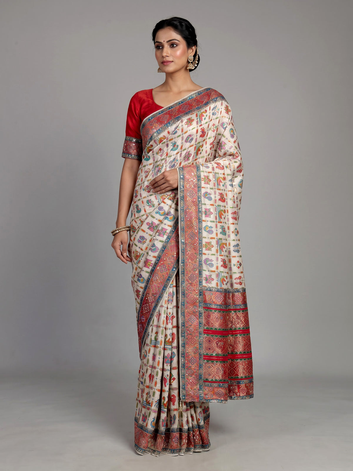 Cream modal satin saree with colourful motifs and intricate zari embellishments