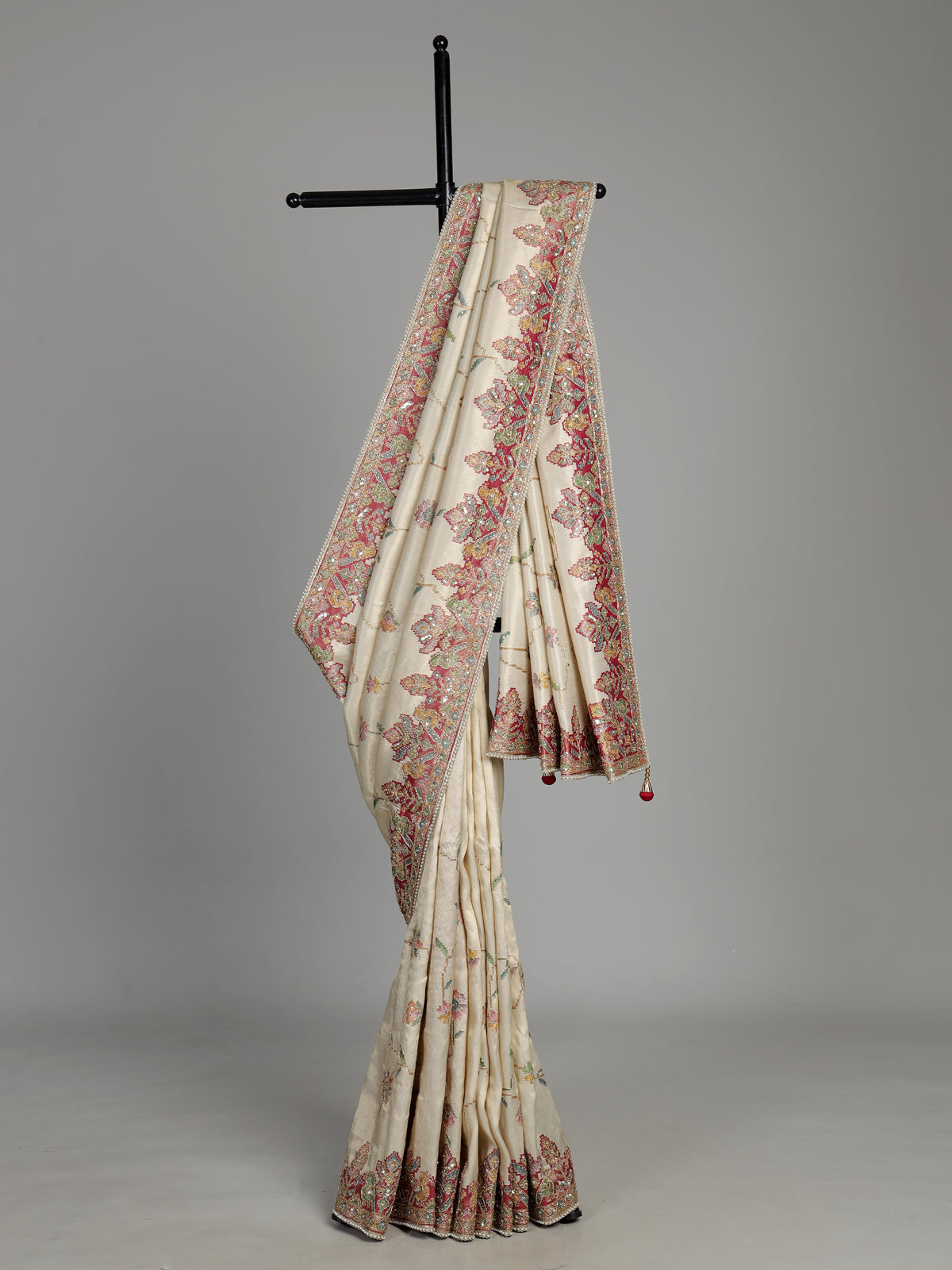 Cream pojisan silk saree with floral motifs and ornate zardosi embroidery