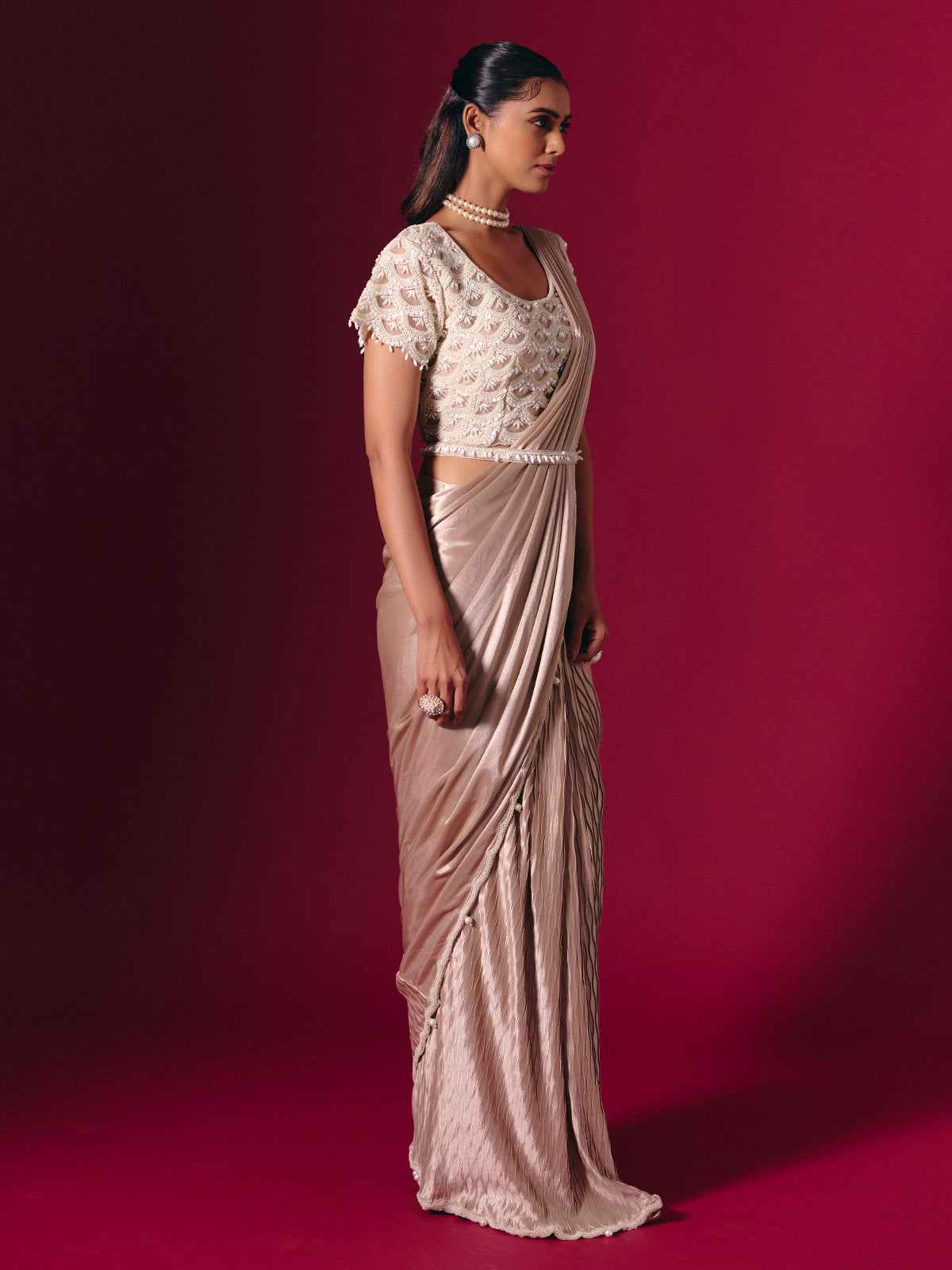 Pastel peach shimmer saree with elegant pearl embellishments