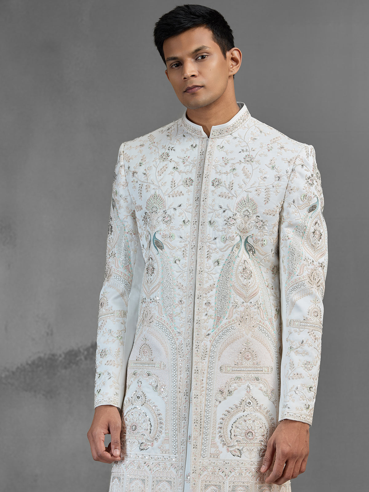 Cream silk sherwani with aqua peacock thread work design