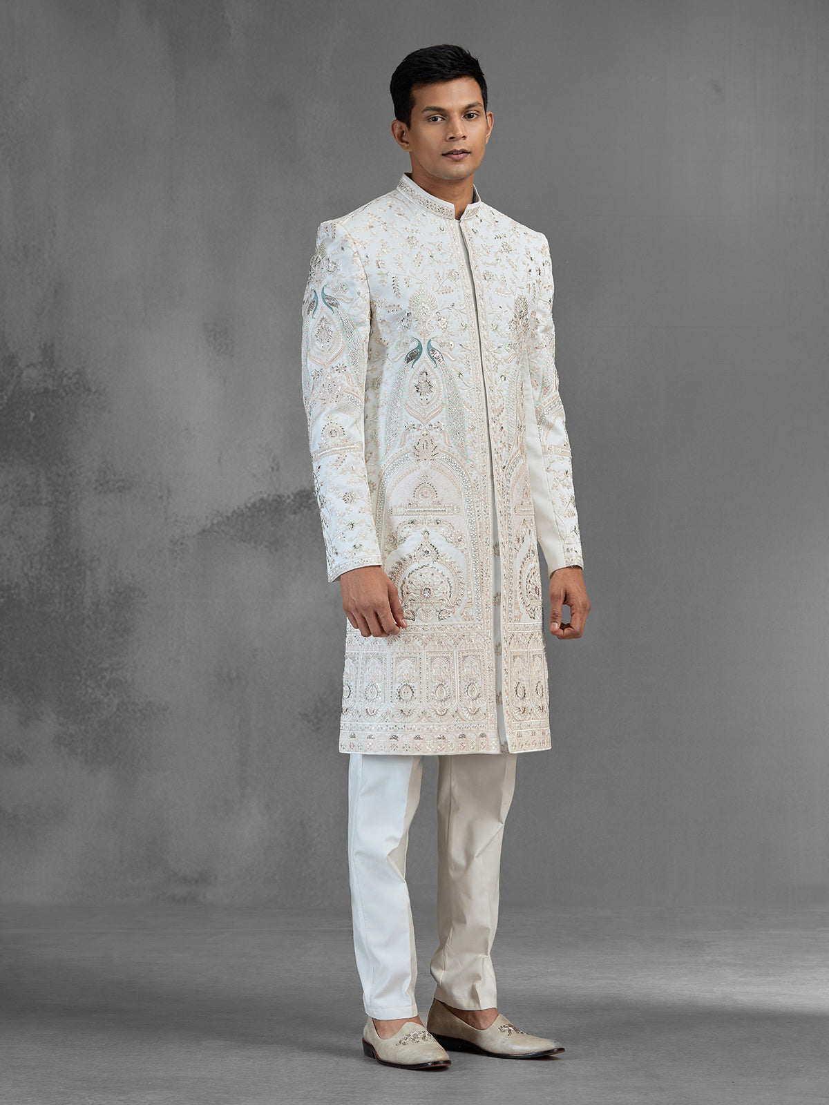 Cream silk sherwani with aqua peacock thread work design