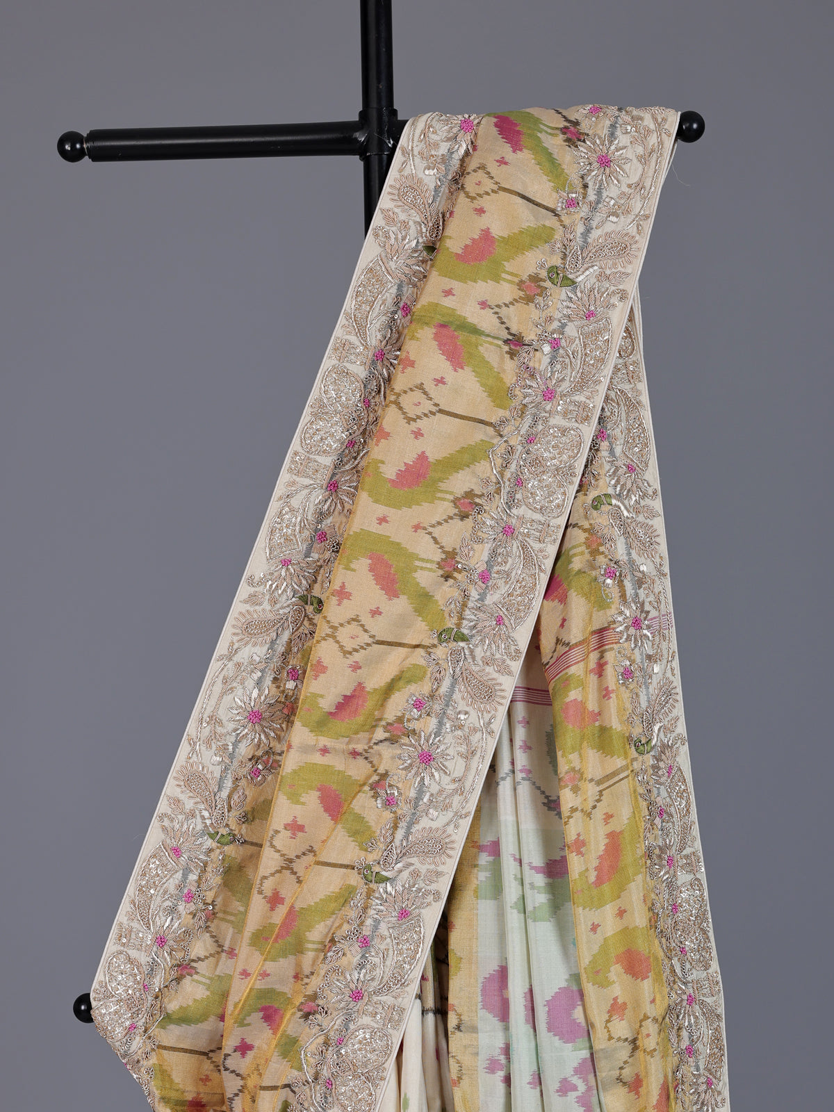 Cream patola silk saree with peacock motif contrast border and pallu