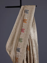 Pastel beige silk saree with delicate traditional embellishments