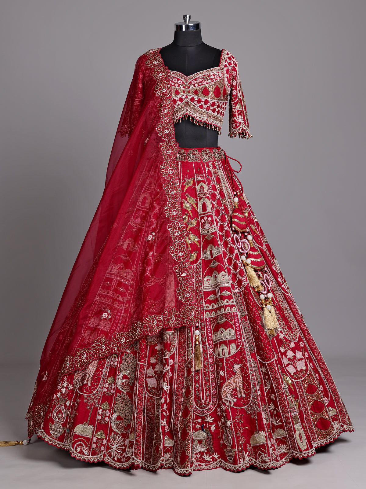 Maroon raw silk lehenga choli with artistic motifs and tassels