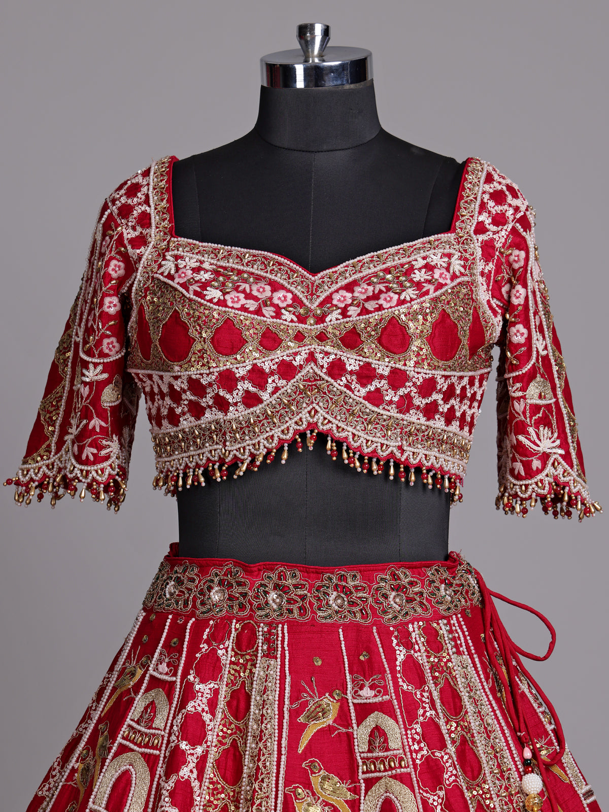 Maroon raw silk lehenga choli with artistic motifs and tassels