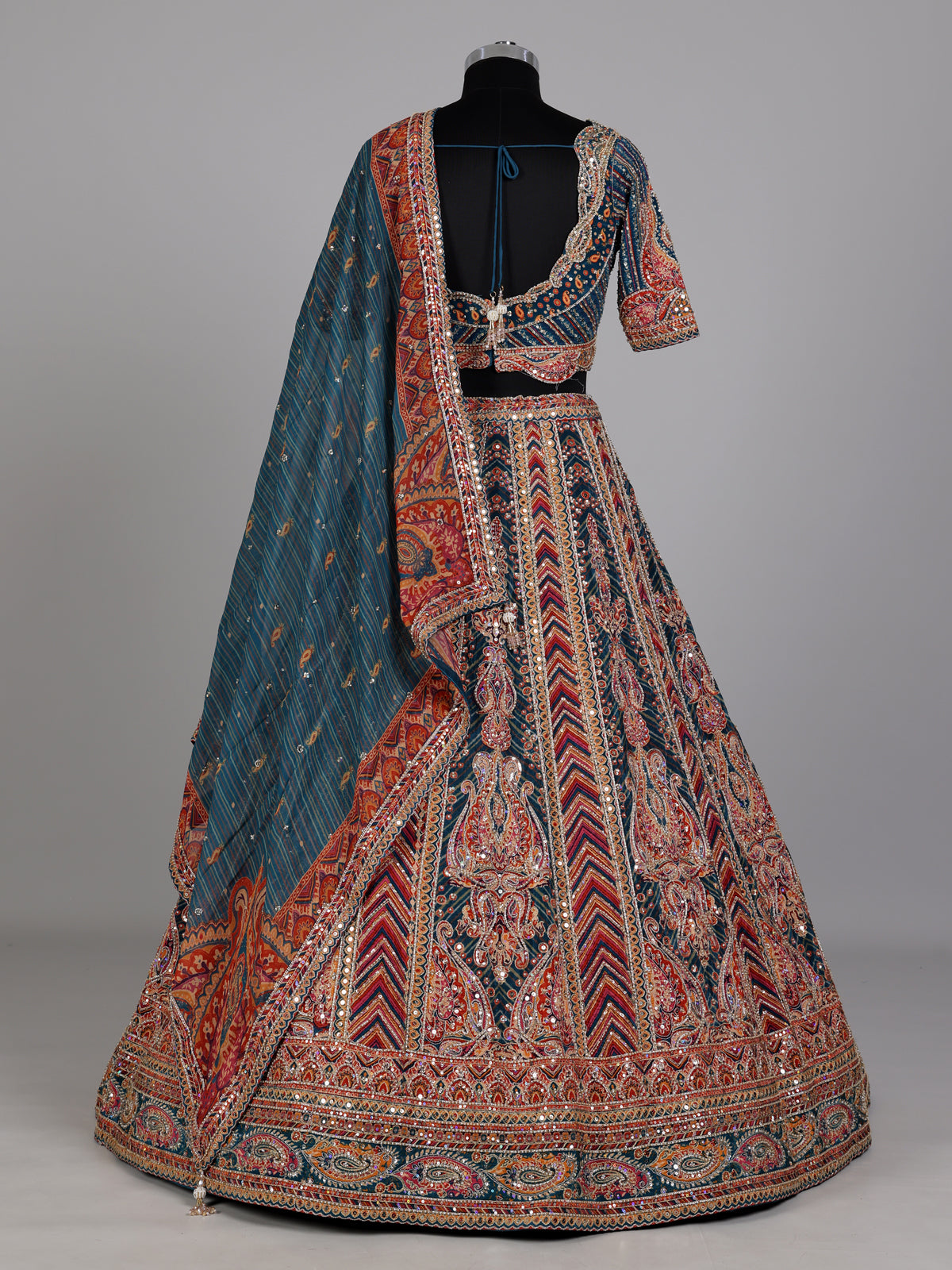Teal blue lehenga choli with rust paisley detailing
