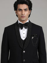 Jet black three-piece tuxedo suit with crystal brooch and cutdana