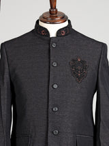 Jet black textured jodhpuri suit for mens with crest motif