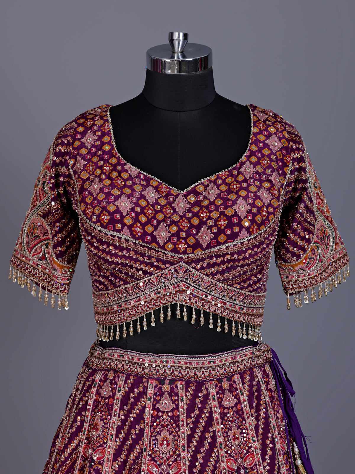 Purple silk lehenga choli with chevron panels and embellished drape