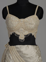 Cream chiffon georgette lehenga choli with pearl and tassel embellishments