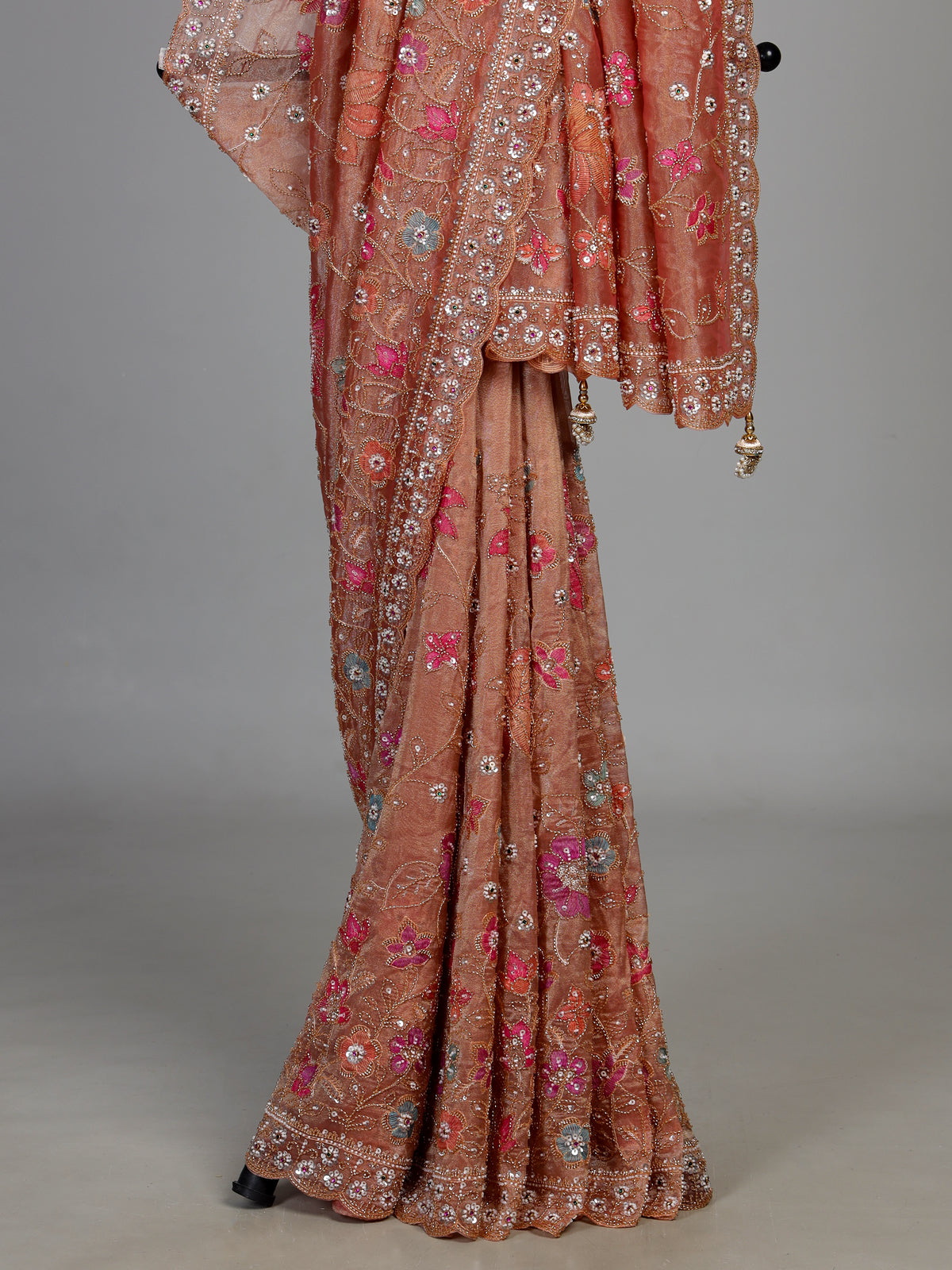 Pastel peach tissue silk saree with floral cutdana and tassels